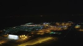 5K aerial stock footage Track a civilian plane as it lands at Oakland International Airport, Oakland, California, night Aerial Stock Footage | DCSF06_103