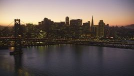 5K Aerial Video Flying by the Bay Bridge, skyline in the background, Downtown San Francisco, California, twilight Aerial Stock Footage | DCSF07_098