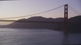 5K Aerial Video Fly low to approach Golden Gate Bridge, pan to reveal a cargo ship, San Francisco, California, twilight Aerial Stock Footage | DCSF10_039