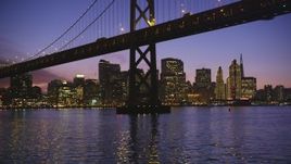 5K Aerial Video Fly low beneath Bay Bridge with a view of the Downtown San Francisco skyline, California, twilight Aerial Stock Footage | DCSF10_065