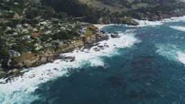 5K Aerial Video Flyby waves crashing below coastal homes and tilt up to the coastline, Carmel, California Aerial Stock Footage | DCSF11_016