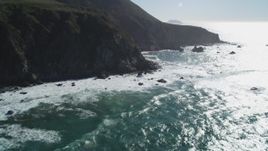 5K Aerial Video Tilt from ocean waves to reveal tall coastal cliffs, Big Sur, California Aerial Stock Footage | DCSF11_022