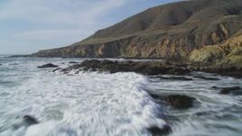 5K aerial stock footage of flying low over waves crashing into coastal cliffs, Harmony, California Aerial Stock Footage | DFKSF03_026