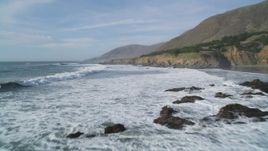 5K aerial stock footage of flying over waves rolling toward coastal cliffs, Harmony, California Aerial Stock Footage | DFKSF03_028