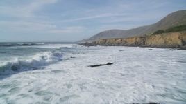 5K aerial stock footage of flying low over waves rolling toward coastal cliffs, Harmony, California Aerial Stock Footage | DFKSF03_029
