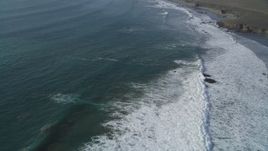 5K aerial stock footage of flying over waves rolling into the coast by Highway 1, San Simeon, California Aerial Stock Footage | DFKSF03_052