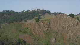 5K aerial stock footage of approaching rocky hillside, Hearst Castle in the distance, San Simeon, California Aerial Stock Footage | DFKSF03_060