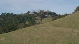 5K aerial stock footage of a wide view of Hearst Castle, eclipsed by a hill, San Simeon, California Aerial Stock Footage | DFKSF03_071