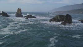 5K aerial stock footage of flying over rock formations and waves off the coast, San Simeon, California Aerial Stock Footage | DFKSF03_077