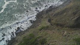 5K aerial stock footage of a bird's eye view of waves below coastal cliffs, Big Sur, California Aerial Stock Footage | DFKSF03_084
