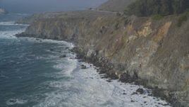 5K aerial stock footage of tilting from crashing waves to coastal cliffs, Big Sur, California Aerial Stock Footage | DFKSF03_099