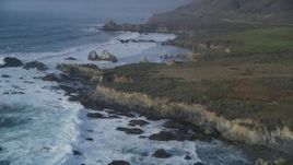 5K aerial stock footage tilt from ocean waves, approach rugged coastal cliffs, rock formations, Big Sur, California Aerial Stock Footage | DFKSF03_103
