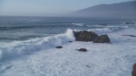 5K aerial stock footage of panning across tall waves crashing into rock formations, Big Sur, California Aerial Stock Footage | DFKSF03_106