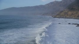 5K aerial stock footage of flying over tall waves, pan right revealing coastal cliffs, Big Sur, California Aerial Stock Footage | DFKSF03_107