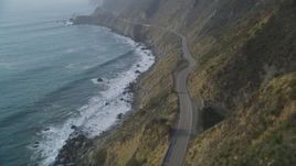 5K aerial stock footage of following Highway 1 coastal road on cliffs, tilt to wider view of coastline, Big Sur, California Aerial Stock Footage | DFKSF03_111