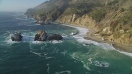 5K aerial stock footage tilt from rock formations in the ocean to reveal coastal cliffs, Big Sur, California Aerial Stock Footage | DFKSF03_118