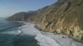 5K aerial stock footage of flying over waves rolling into the base of coastal cliffs, Big Sur, California Aerial Stock Footage | DFKSF03_127