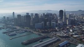 5K aerial stock footage of a reverse view of piers along bay and skyscrapers, Downtown San Francisco, California Aerial Stock Footage | DFKSF05_021