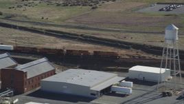 5K aerial stock footage of a train passing industrial buildings, Bay Point, California Aerial Stock Footage | DFKSF08_110