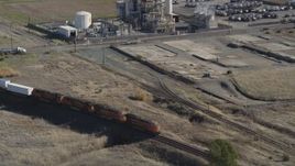 5K aerial stock footage track a train passing by industrial buildings, Bay Point, California Aerial Stock Footage | DFKSF08_111