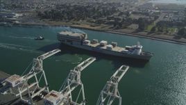 5K aerial stock footage of a reverse view of a cargo ship passing cargo cranes in the Port of Oakland, California Aerial Stock Footage | DFKSF09_020