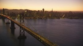 5K aerial stock footage of a reverse view of the Bay Bridge and skyline of Downtown San Francisco, California, twilight Aerial Stock Footage | DFKSF10_086
