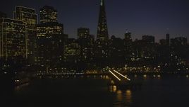 5K aerial stock footage of flying low by piers and skyscrapers in Downtown San Francisco, California, night Aerial Stock Footage | DFKSF10_102