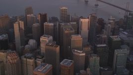 5K aerial stock footage tilt from city skyscrapers to reveal Bay Bridge, Downtown San Francisco, California, sunset Aerial Stock Footage | DFKSF14_016