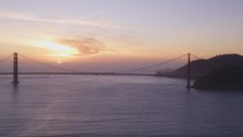 5K aerial stock footage of flying by the famous Golden Gate Bridge with view of setting sun, San Francisco, California, sunset Aerial Stock Footage | DFKSF14_025