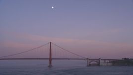 5K aerial stock footage of flying by Golden Gate Bridge with the moon in the sky, San Francisco, California, twilight Aerial Stock Footage | DFKSF14_031