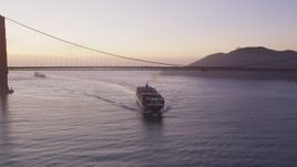 5K aerial stock footage of flying by cargo ship under Golden Gate Bridge, San Francisco, California, twilight Aerial Stock Footage | DFKSF14_044