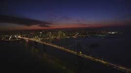 5K aerial stock footage of flying by the Bay Bridge, with a view of Downtown San Francisco skyscrapers, California, night Aerial Stock Footage | DFKSF14_082