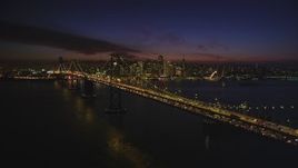 5K aerial stock footage flyby the Bay Bridge, with views of skyscrapers in Downtown San Francisco, California, night Aerial Stock Footage | DFKSF14_085