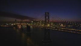 5K aerial stock footage of the Bay Bridge, with views of Downtown San Francisco skyscrapers, California, night Aerial Stock Footage | DFKSF14_086