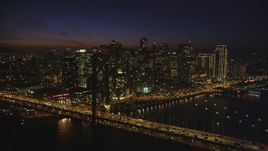 5K aerial stock footage of flying by the Bay Bridge with a view of skyscrapers in Downtown San Francisco, California, night Aerial Stock Footage | DFKSF14_088