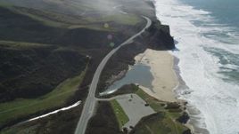 5K aerial stock footage tilt to Pomponio Creek and beach beside Highway 1 on the coast, San Gregorio, California Aerial Stock Footage | DFKSF15_092