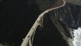 5K aerial stock footage of light traffic on the Bixby Creek Bridge above coastal cliffs, Big Sur, California Aerial Stock Footage | DFKSF16_075