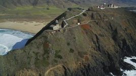 5K aerial stock footage of a reverse view of the Point Sur Light Station, waves crashing against coastline, Big Sur, California Aerial Stock Footage | DFKSF16_093