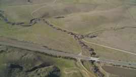 5K aerial stock footage of a reverse view of grassy hills, reveal country road in San Luis Obispo County, California Aerial Stock Footage | DFKSF16_144