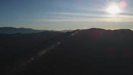 5K aerial stock footage of flying by a mountain range with the sun overhead, San Luis Obispo County, California Aerial Stock Footage | DFKSF17_021