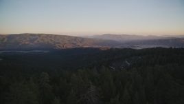 5K aerial of flying low over trees toward mountains, Los Padres National Forest, California, twilight Aerial Stock Footage | DFKSF17_053