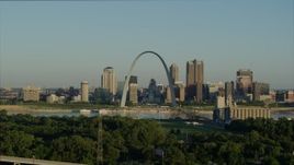 5.7K aerial stock footage ascending over park toward Mississippi River, Arch and skyline at sunrise, Downtown St. Louis, Missouri Aerial Stock Footage | DX0001_000523