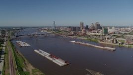 5.7K aerial stock footage side view of Mississippi River and barges with city in the distance, Downtown St. Louis, Missouri Aerial Stock Footage | DX0001_000580