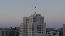 5.7K aerial stock footage of flags atop a downtown apartment building at twilight, Downtown St. Louis, Missouri Aerial Stock Footage | DX0001_000886