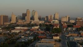 5.7K aerial stock footage flying by the city skyline at sunrise, seen from an industrial area, Downtown Kansas City, Missouri Aerial Stock Footage | DX0001_001006