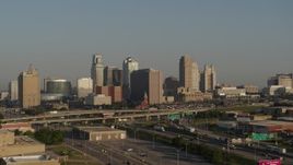 5.7K aerial stock footage of a side view of the downtown skyline and freeway interchange at sunrise, Downtown Kansas City, Missouri Aerial Stock Footage | DX0001_001024