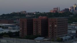 5.7K aerial stock footage orbit front of brick office building at twilight, city skyline in background, Kansas City, Missouri Aerial Stock Footage | DX0001_001186