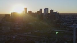 5.7K aerial stock footage of the rising sun behind the city skyline at sunrise in Downtown Denver, Colorado Aerial Stock Footage | DX0001_001615