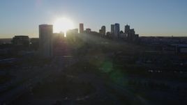 5.7K aerial stock footage of sun and city skyline, seen while flying by skyscraper at sunrise in Downtown Denver, Colorado Aerial Stock Footage | DX0001_001625