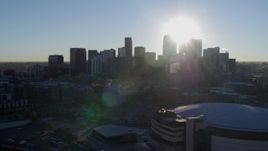 5.7K aerial stock footage of the rising sun behind the city skyline, seen from arena in Downtown Denver, Colorado Aerial Stock Footage | DX0001_001628